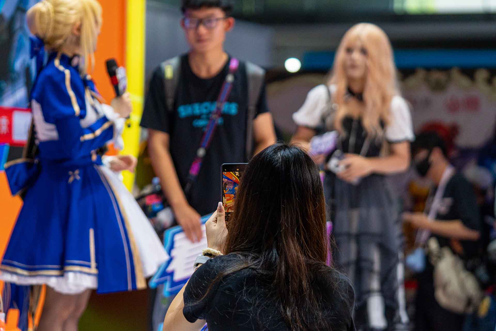 Female visitor takes photo of cosplayers at ChinaJoy 2025