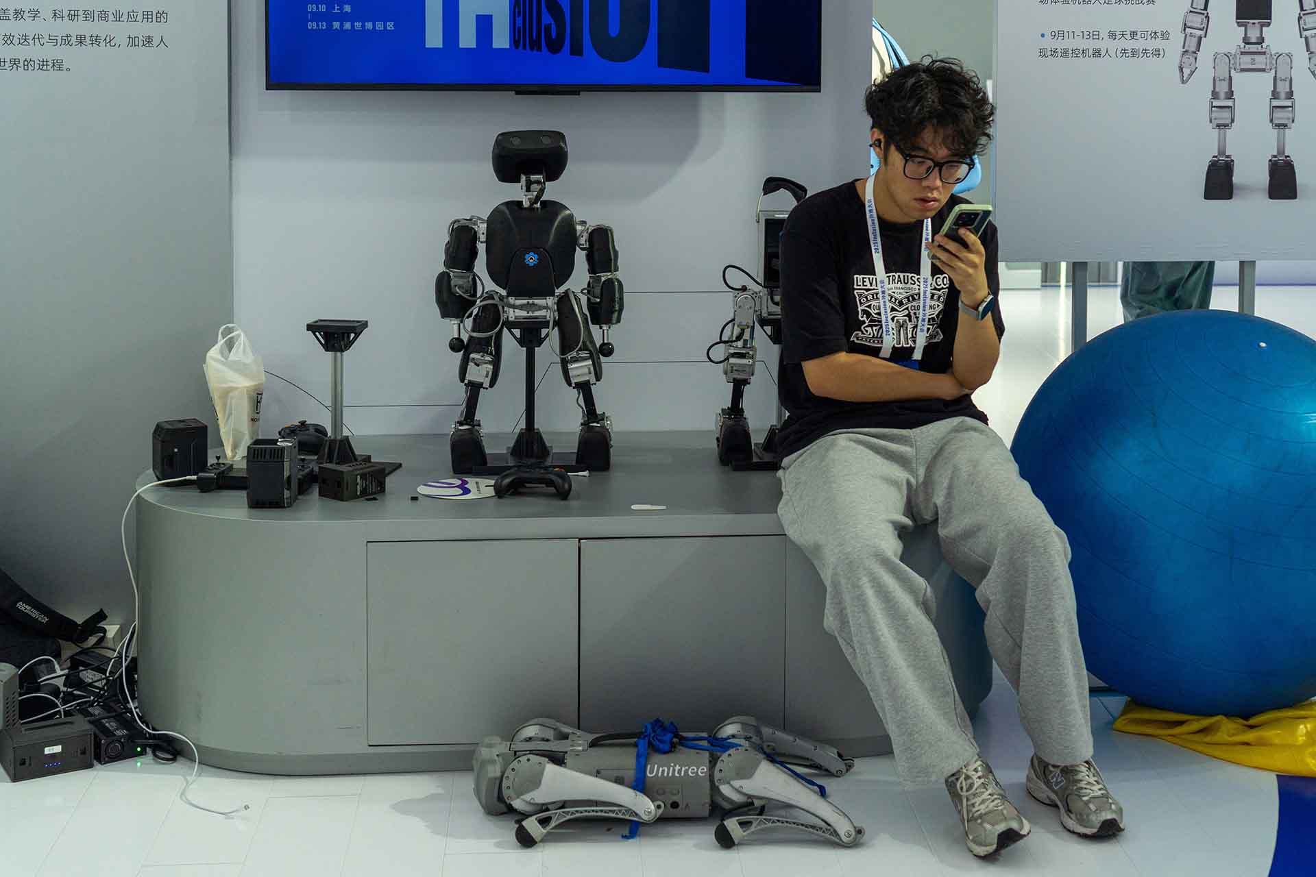 Staff member standing beside displayed robots at event