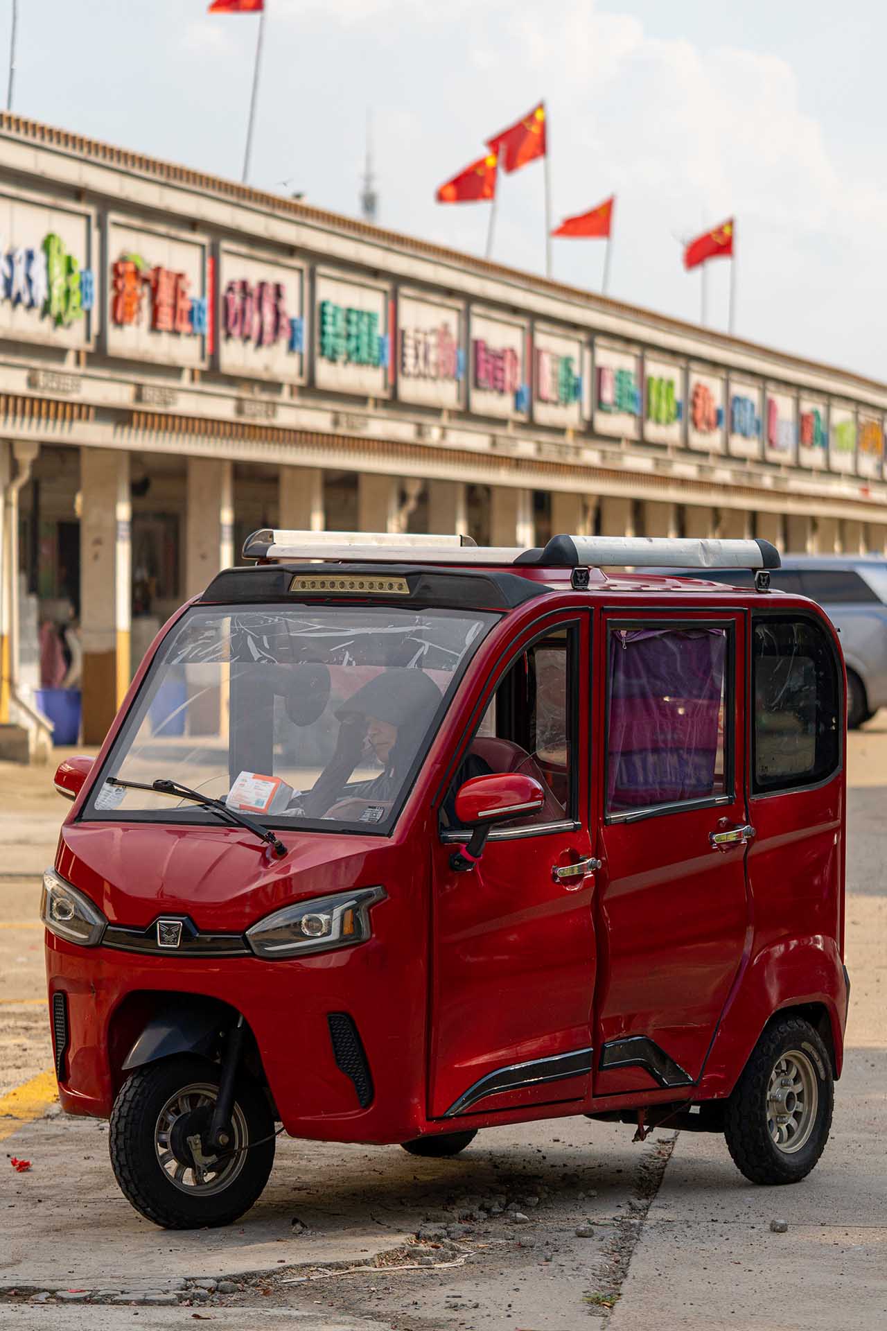 Vendor sitting in her electric car at the market