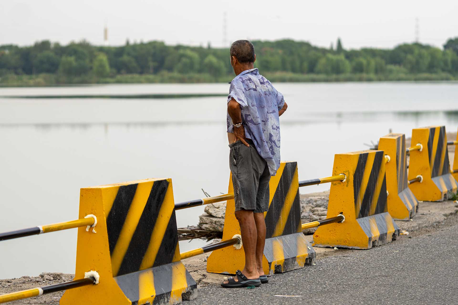 Market worker standing, looking out over the lake waters