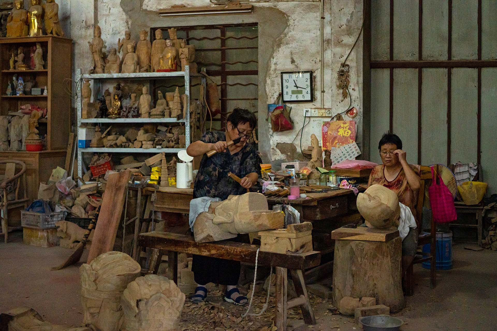 Elderly women carving wooden sculptures in Chongshan