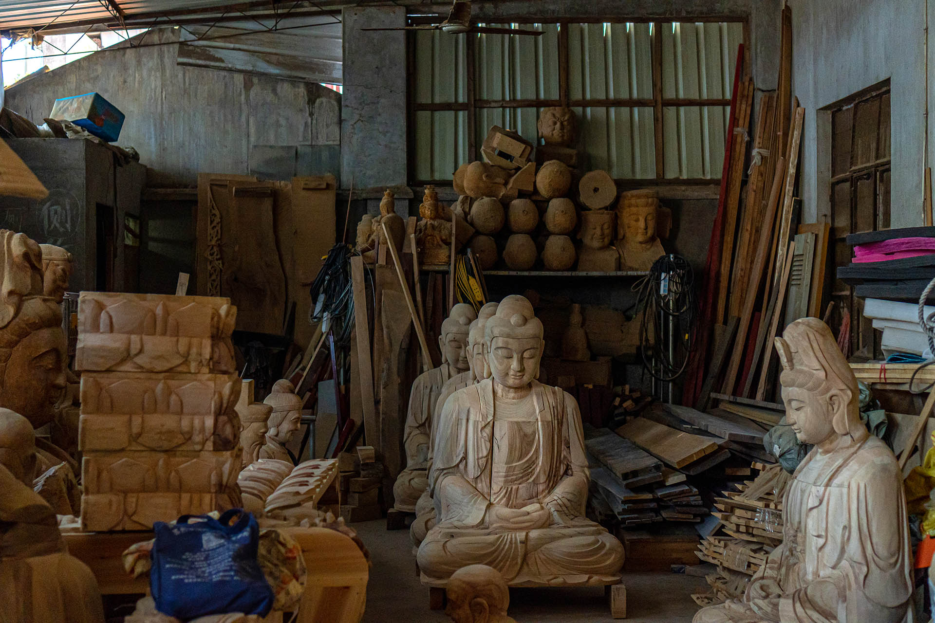 Partially finished wooden sculptures displayed in workshop