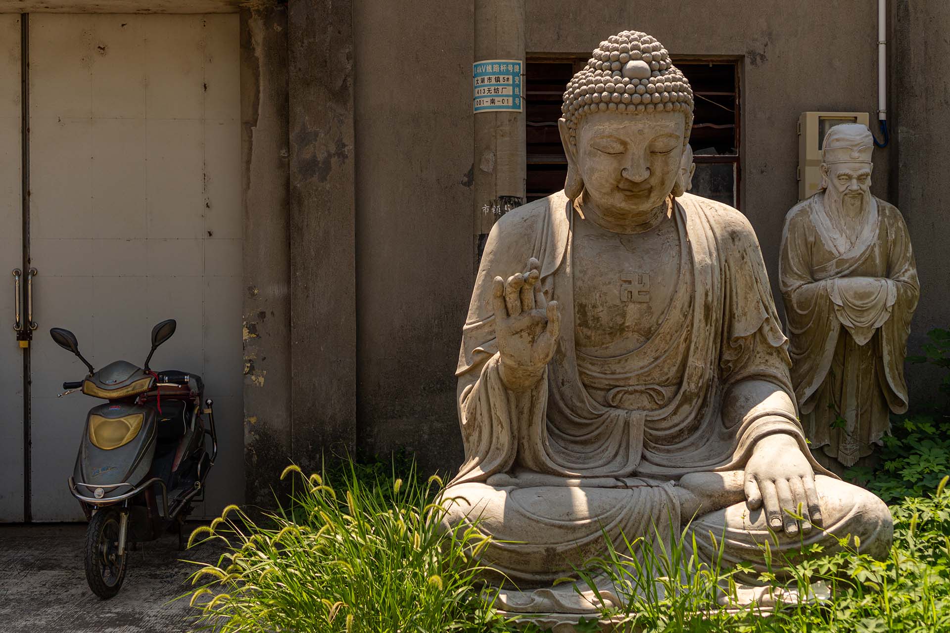 Large Buddha statues displayed in front of workshop