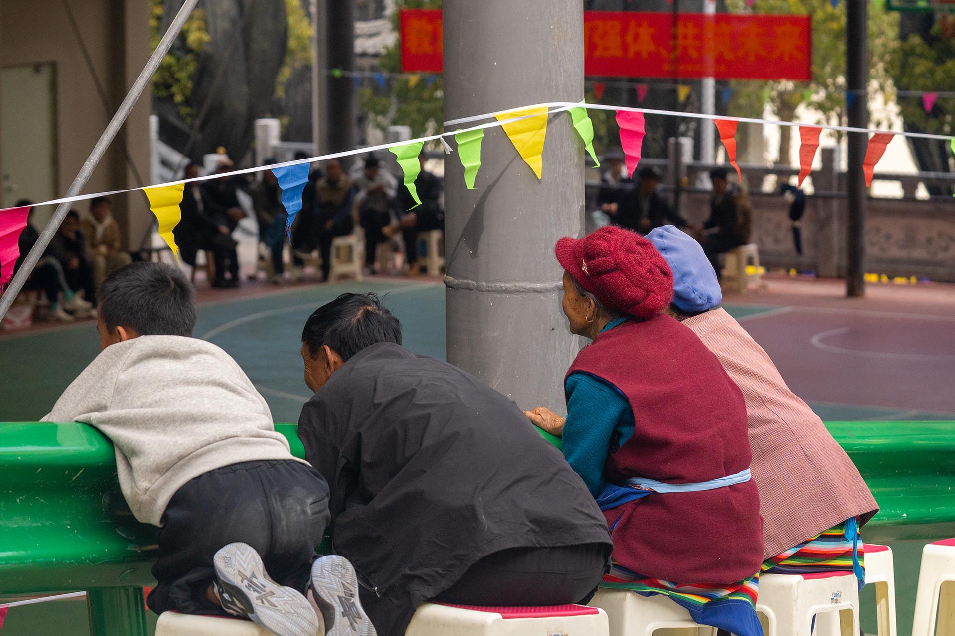 Elderly and children watching local basketball game together